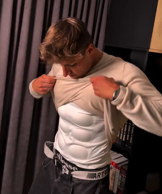 Wearer lifting a sweater to reveal the compression shirt underneath